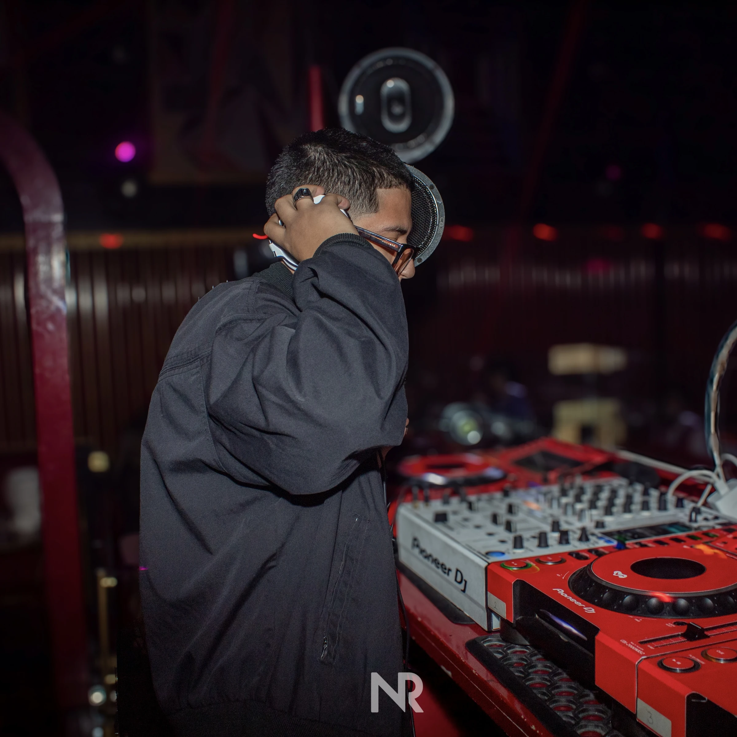 Fisher G ajustándose los audífonos junto al mixer Pioneer en la cabina